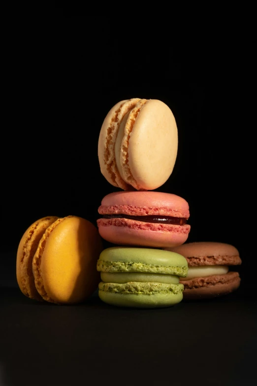 a stack of macaroons, the middle one with orange and some green