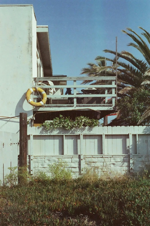 a white wall and gate outside of an old apartment building