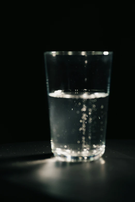water glass on table with light reflecting off the top