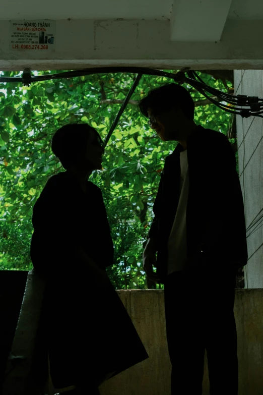 a woman and man standing by some trees