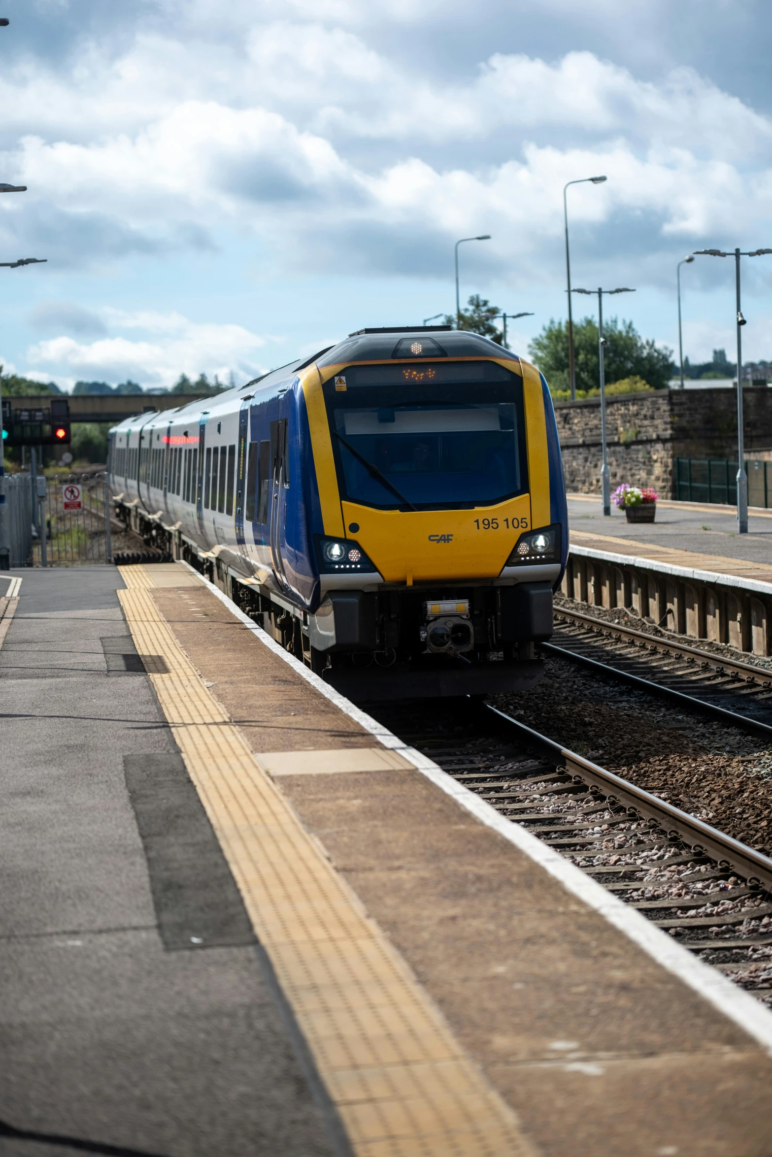 an yellow and blue train is on the tracks