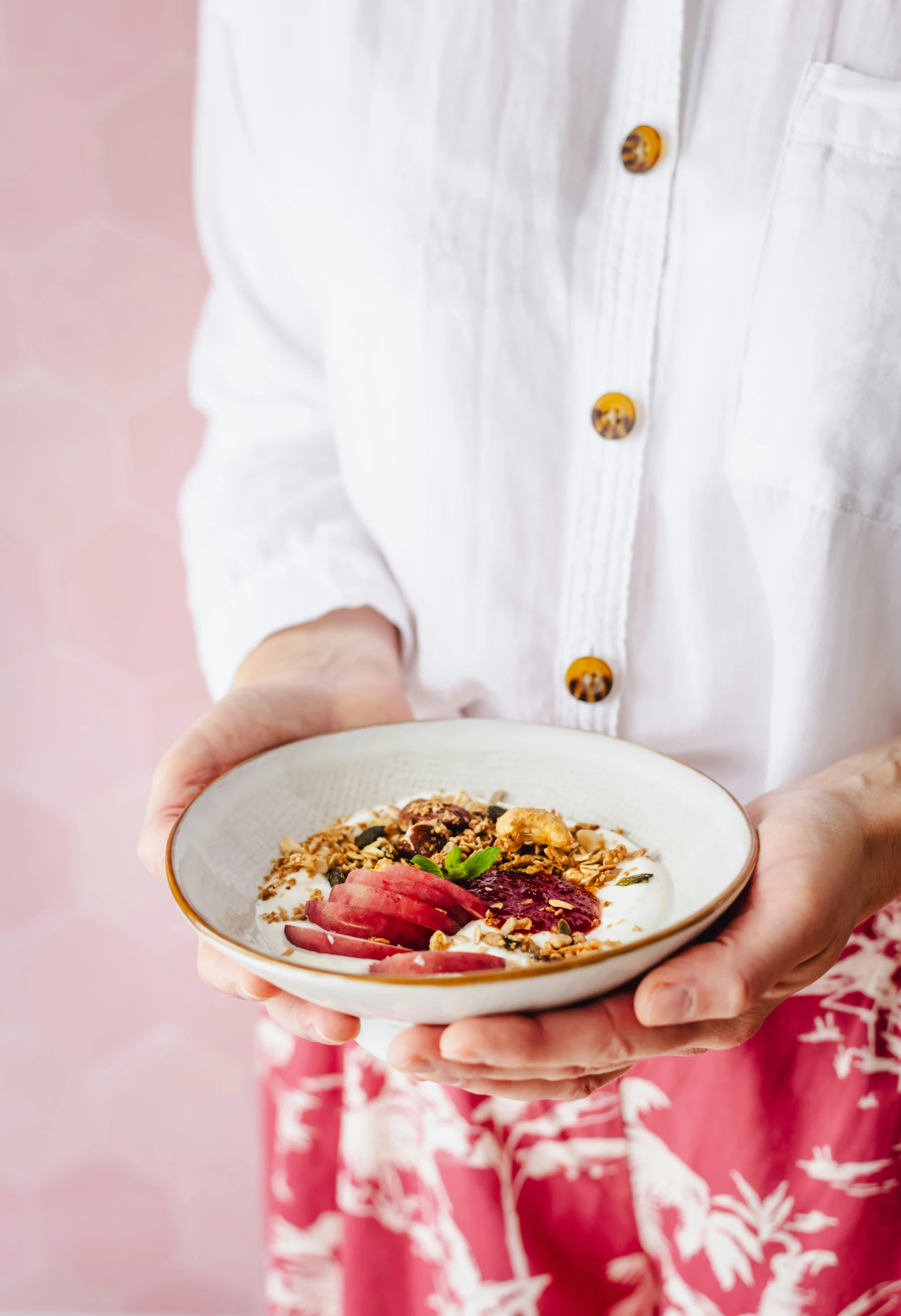 a woman holding a white plate with some food