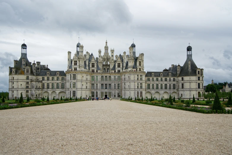 a large old house with tall towers and stone walkway