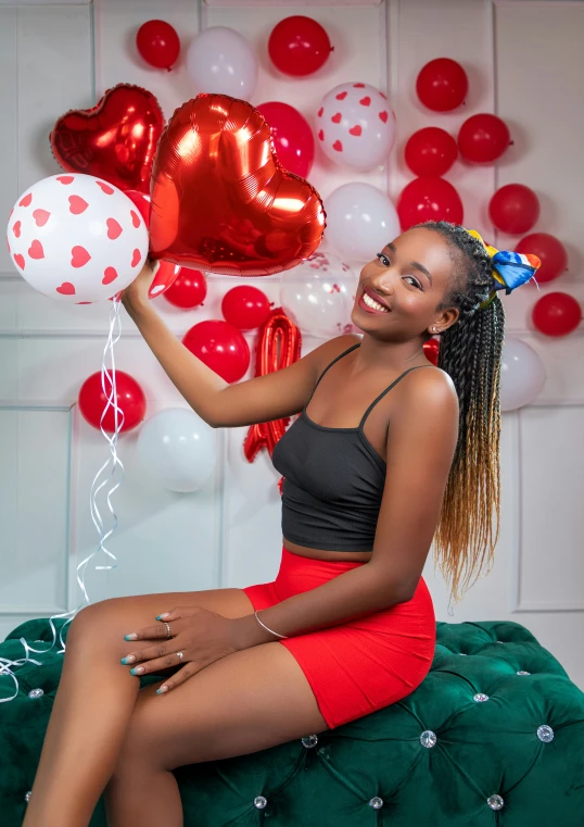 woman sitting with balloons in front of wall