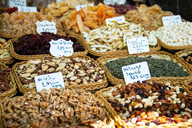 an assortment of nuts and dried fruits on display in baskets