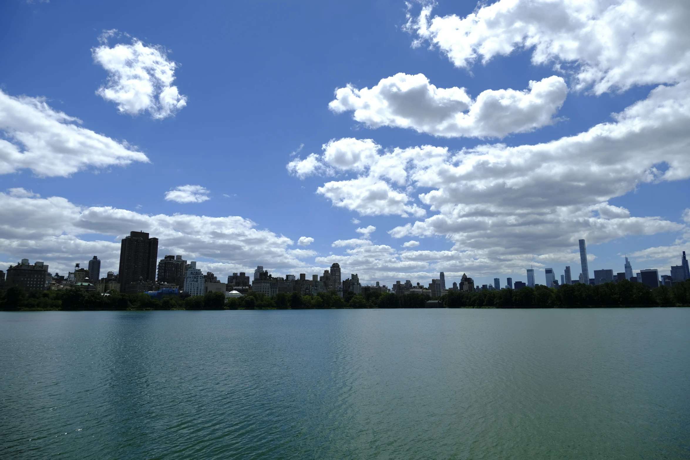 a lake with a few clouds floating over it