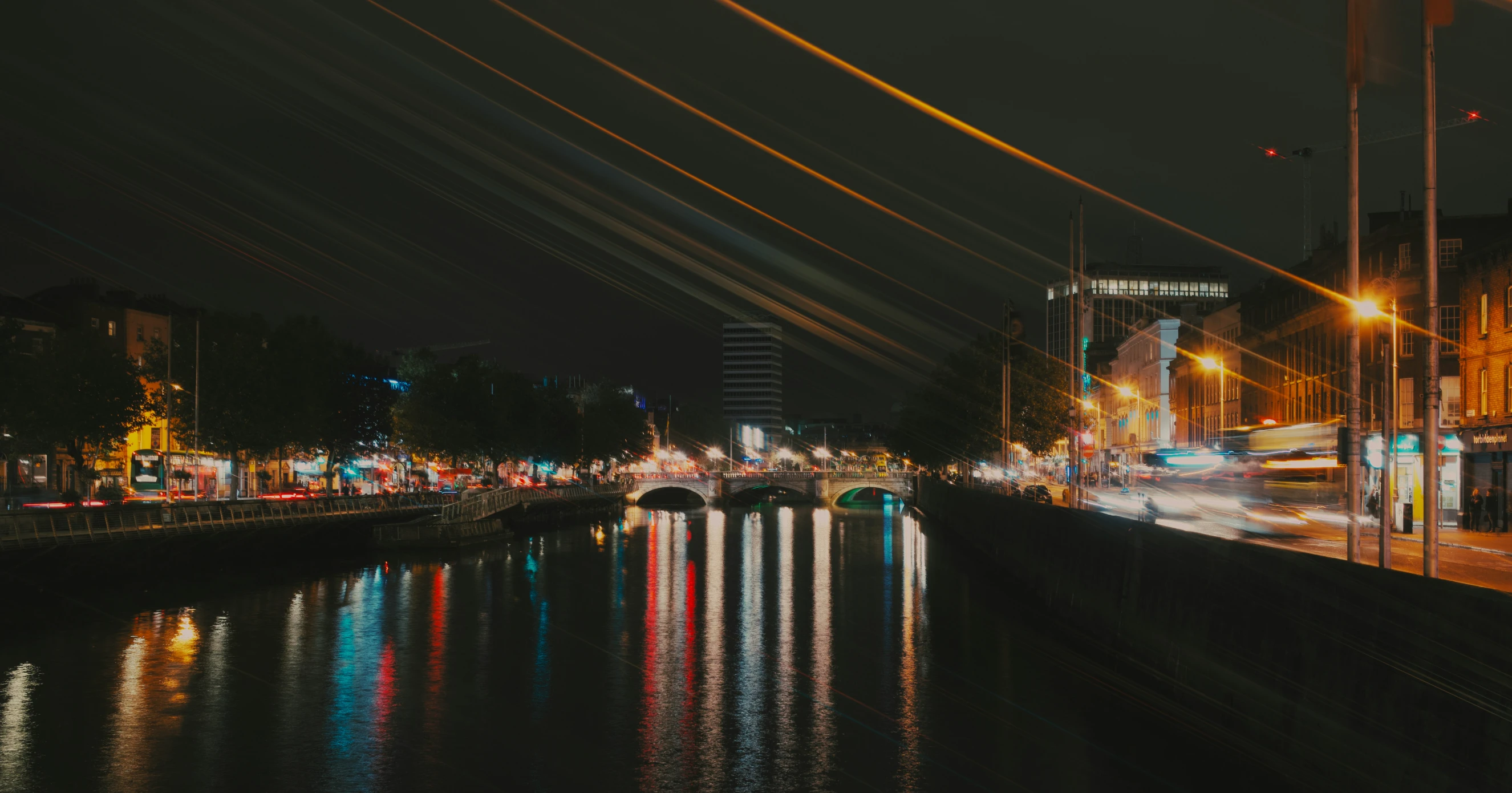 a night view of city lights reflecting in the water