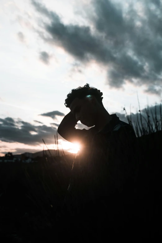 a person standing on top of a field at sunset