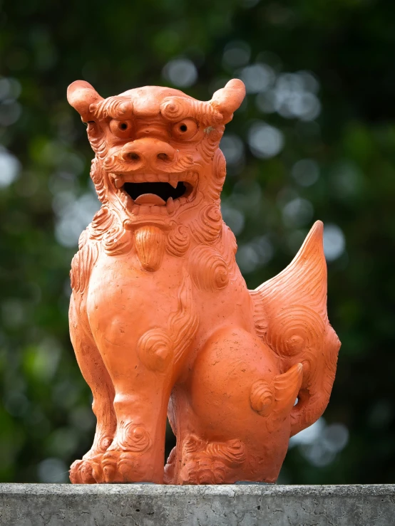 a red statue of a dog on the side of the building