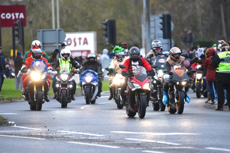 many people on motorcycles ride down the road