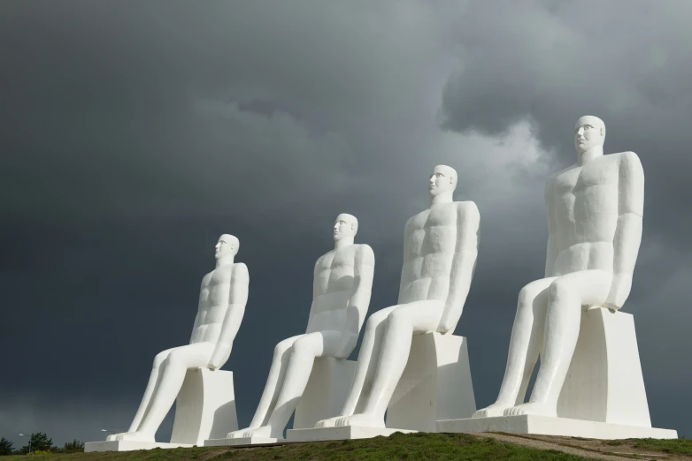 several tall white sculptures on top of a green field