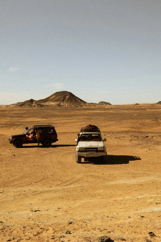 vehicles are parked in the middle of an empty desert area