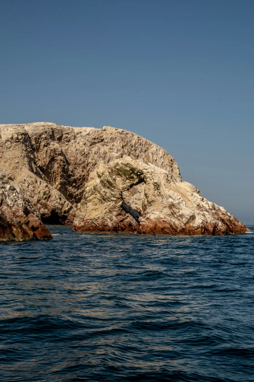 a lone plane flies low over the rocky shore