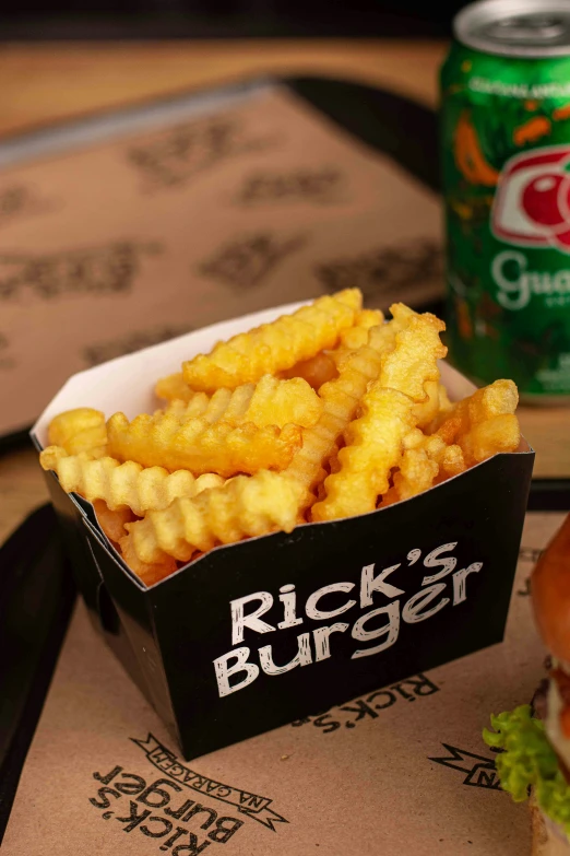 a basket with onion rings sitting next to a can of diet coke