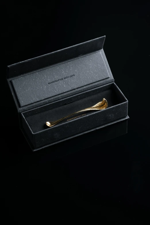 a gold comb that is in a black case