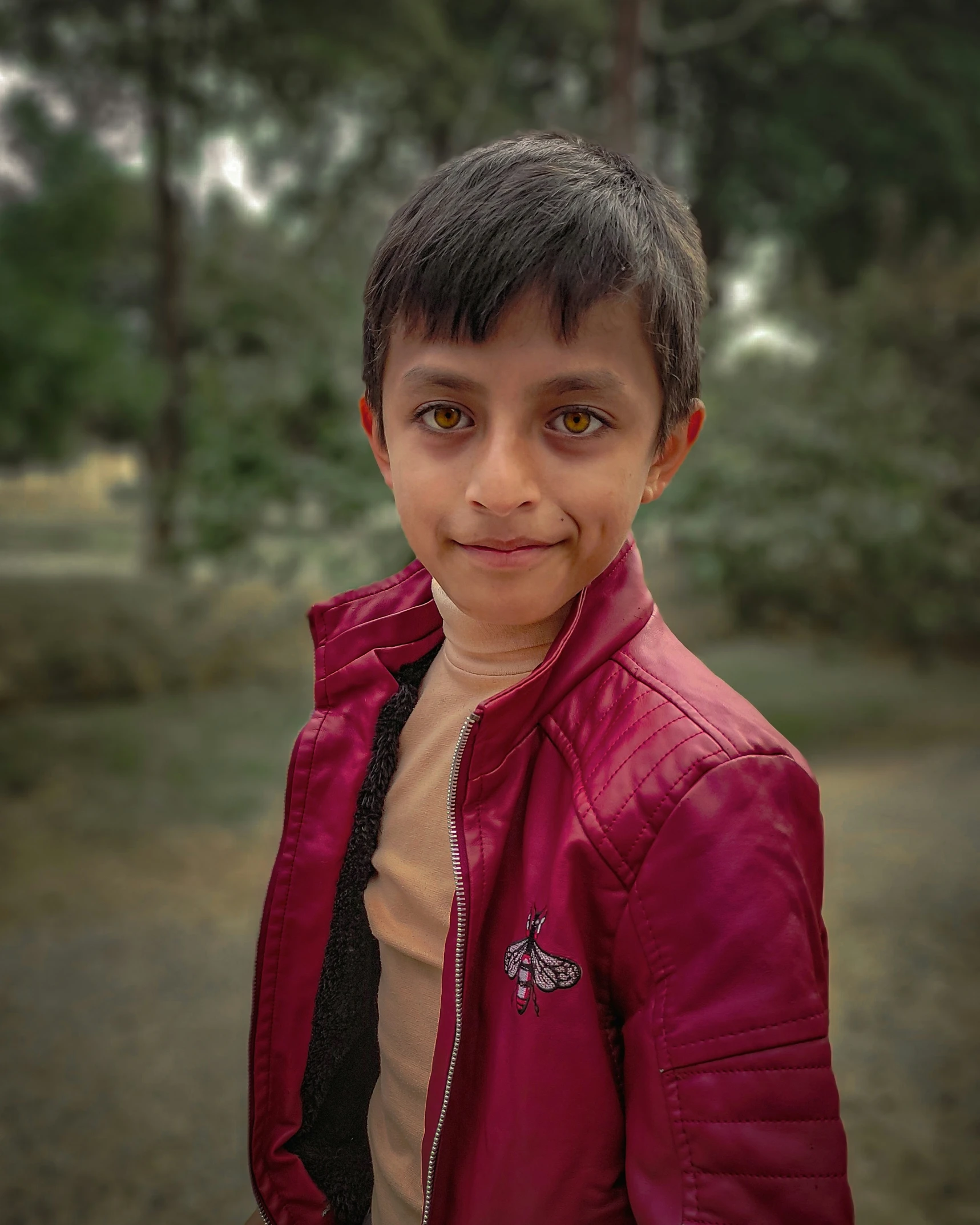 a close up of a young man wearing a pink jacket