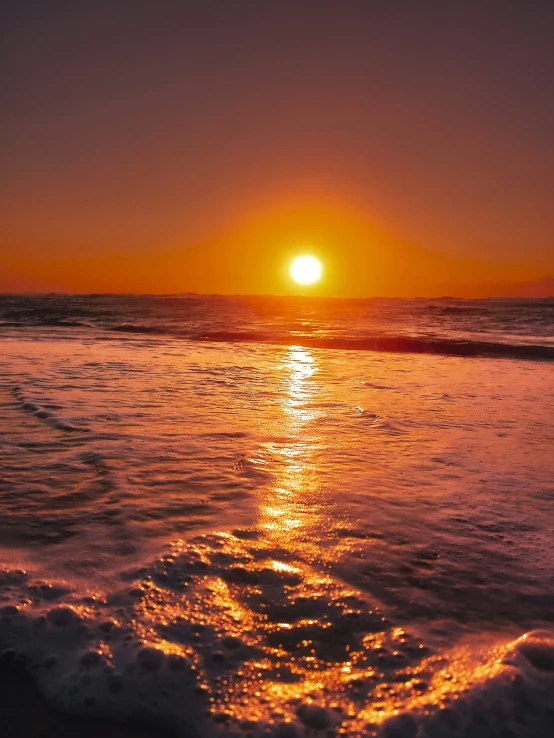 a sunset seen at the beach from a distance