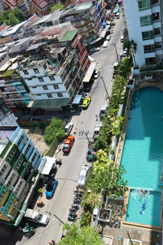 a small swimming pool with a parking lot alongside the city