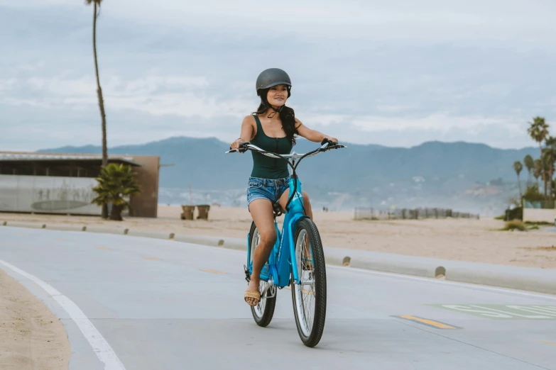 woman in a black top riding a bicycle down a street