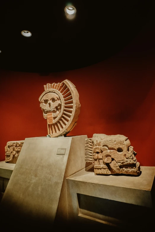 a room with some sculptures and a red wall