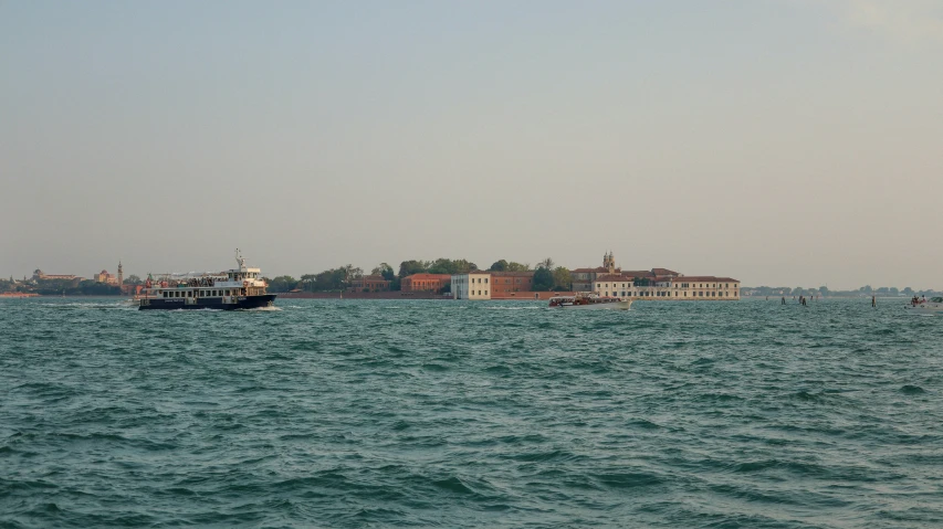 boat traveling on the water near city buildings