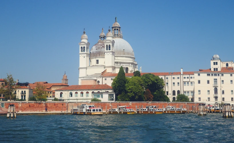 a very large white building sitting next to a lake