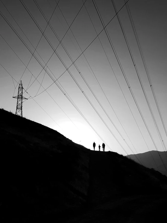 an uphill silhouette is shown with power lines