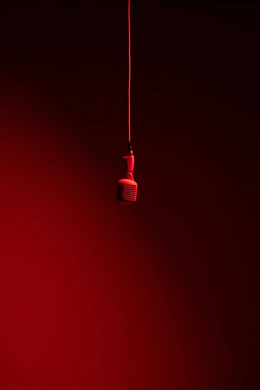 red light bulb hanging on a red wire