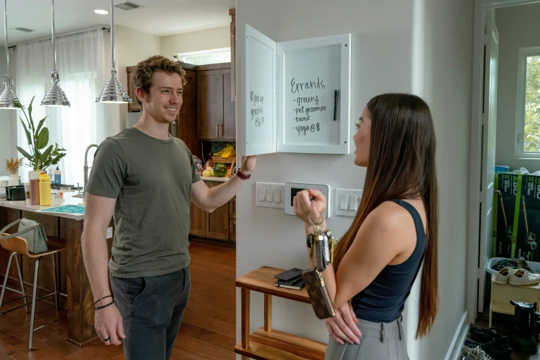 a woman holds an electronic device for a man to use