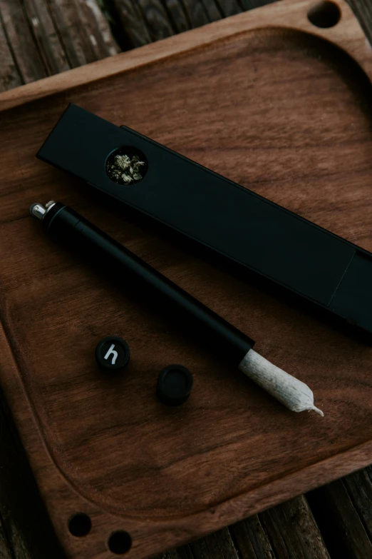 the pen and its cap are laying on a wooden tray