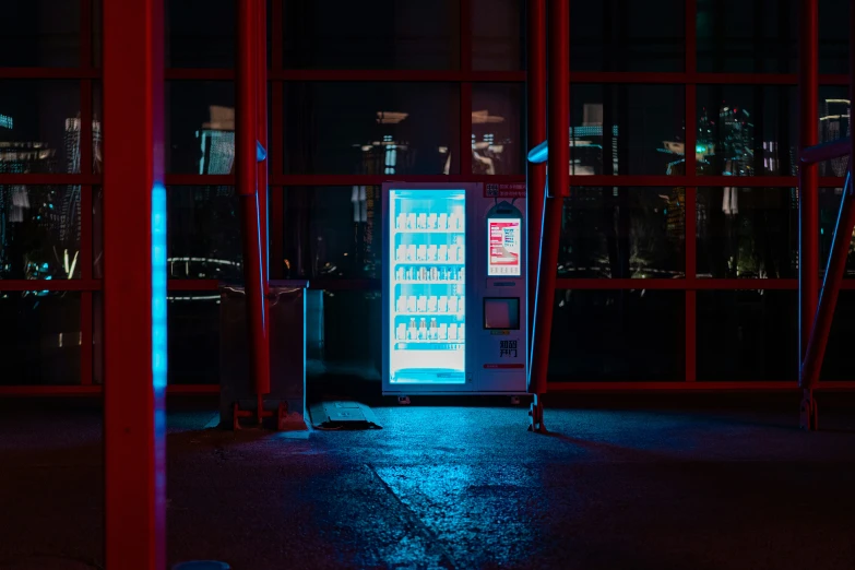 an atm machine illuminated by street lights in front of windows