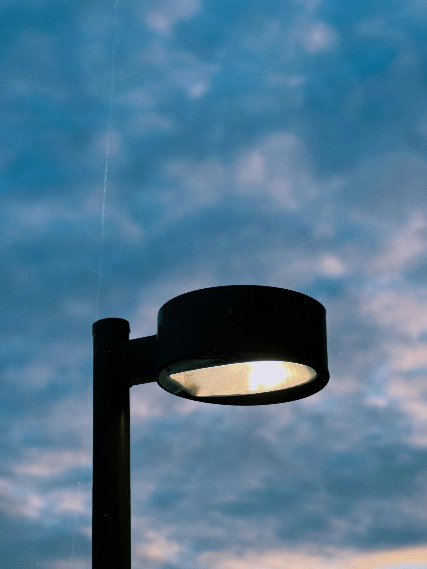 a street light and sky at dusk taken from the ground