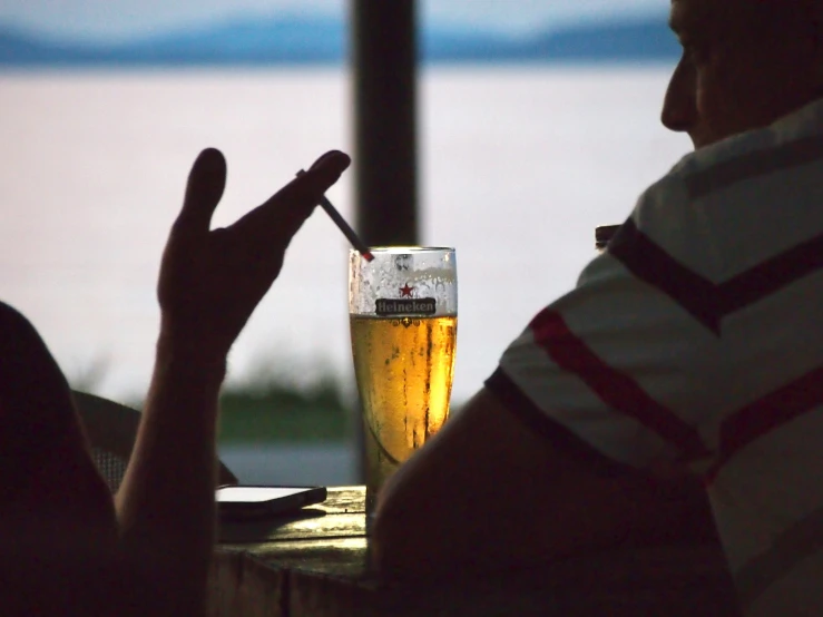 a man sitting at a table next to a glass of beer