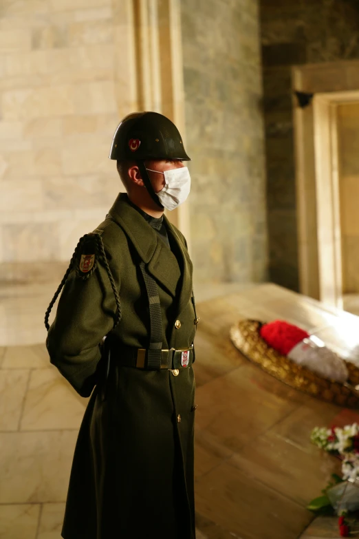 the man is wearing a face mask at the casket