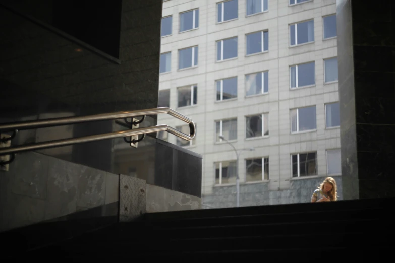 a woman walking up some steps to get out of a tall building