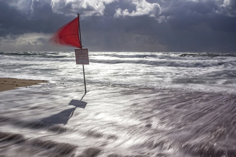 a stop sign next to an ocean with a sky background