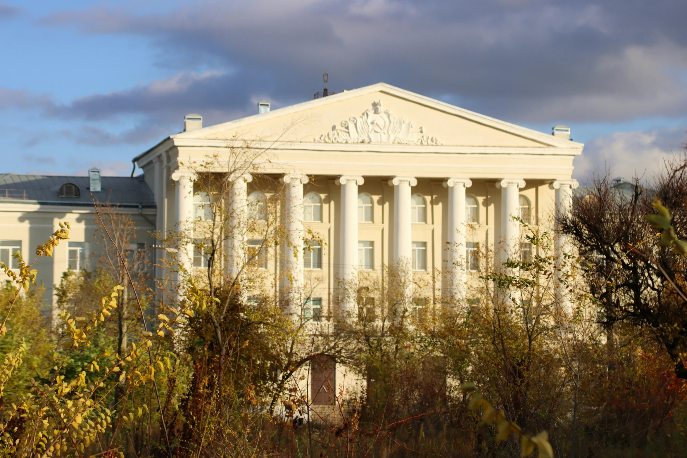 a very large building surrounded by some bushes