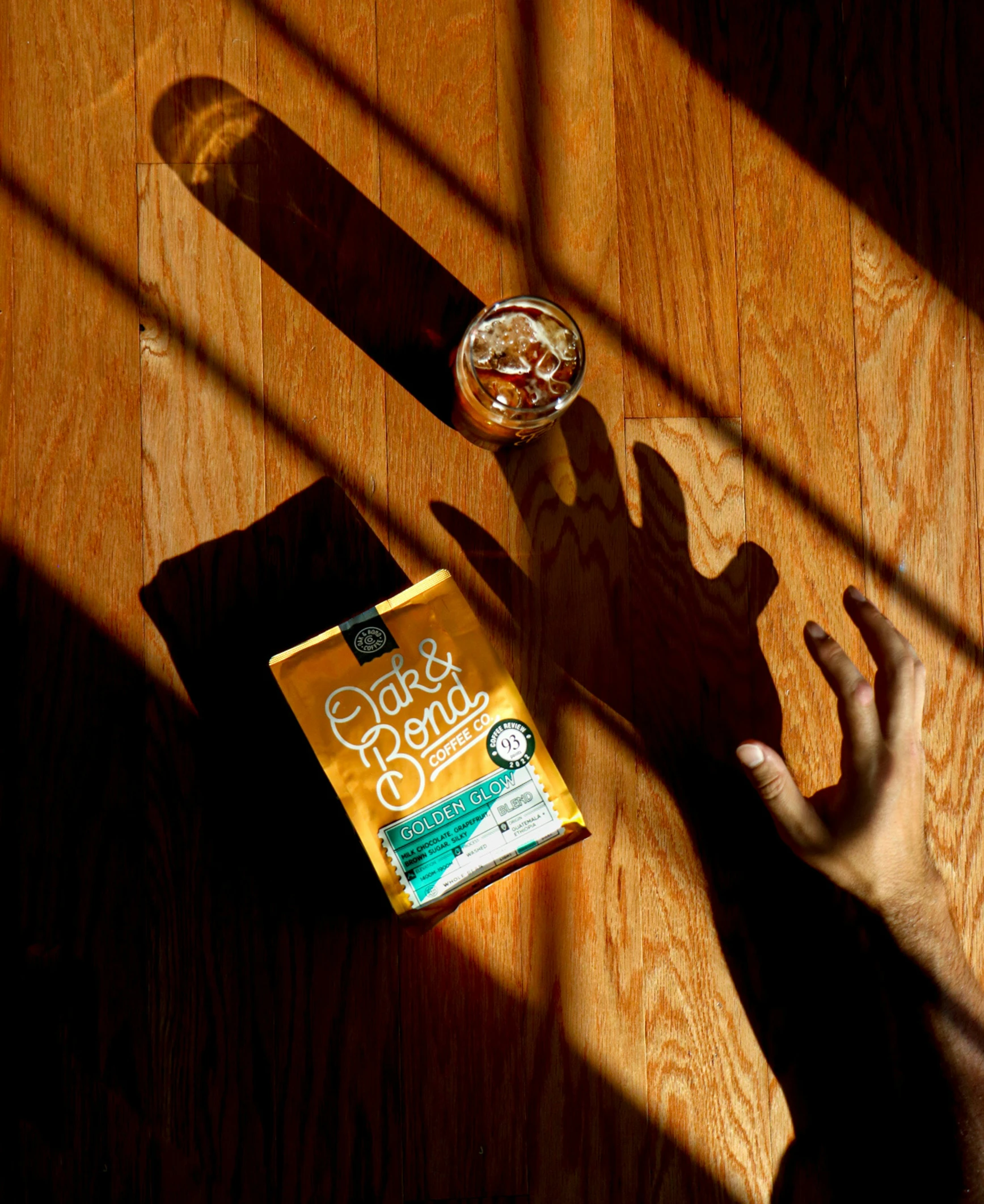 the shadow of someone standing on the floor with his skateboard