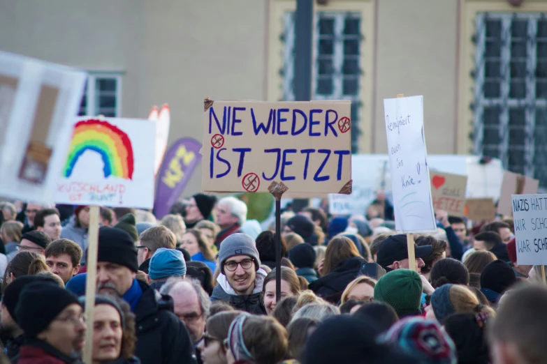 people holding up signs on top of each other