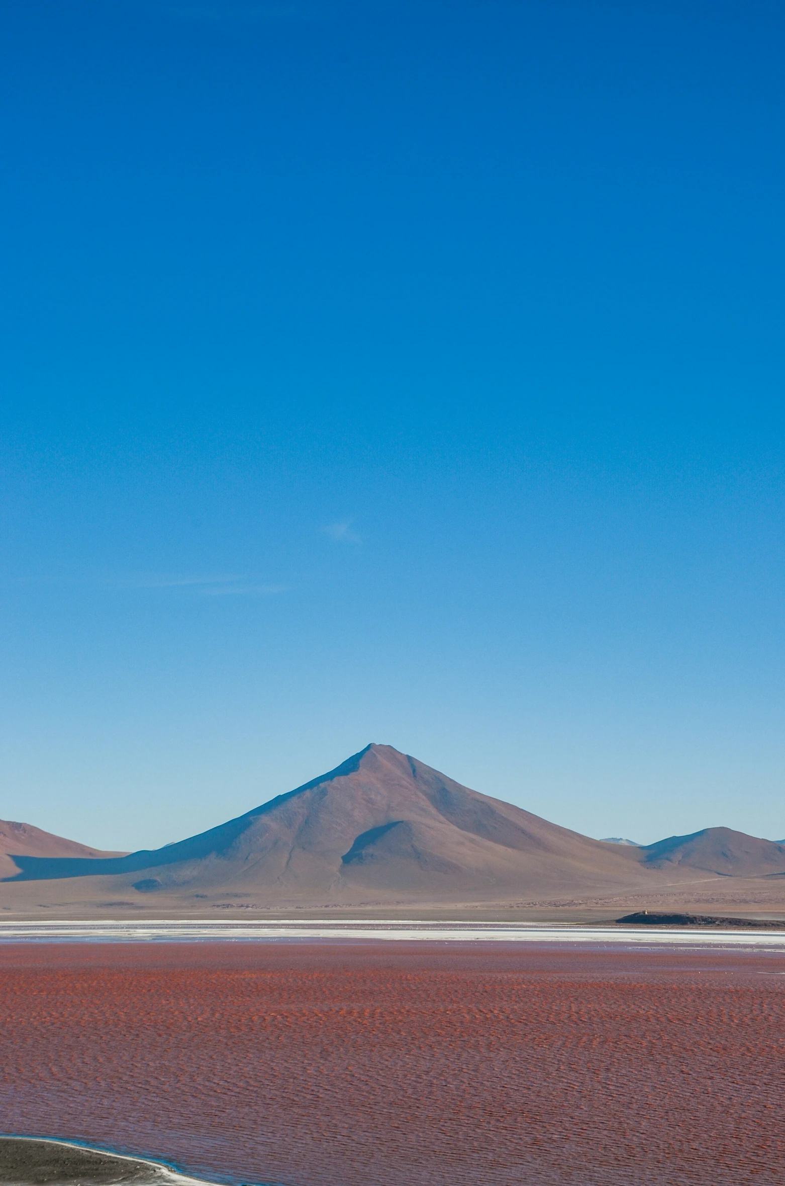 a desert scene with mountains on the far horizon