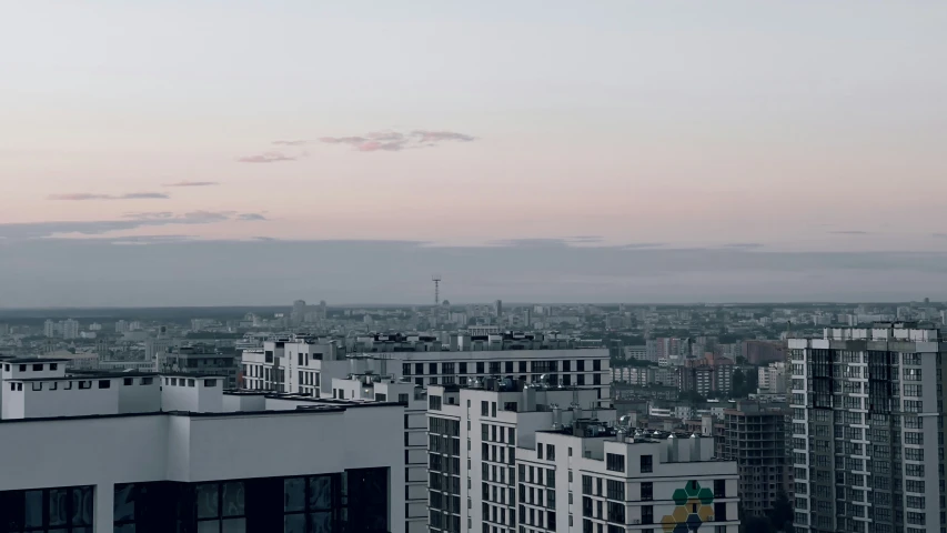 a view from a building at dusk of several buildings in a city