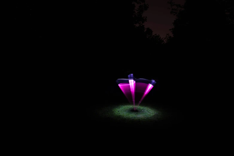 a colorful object is lit on the ground at night