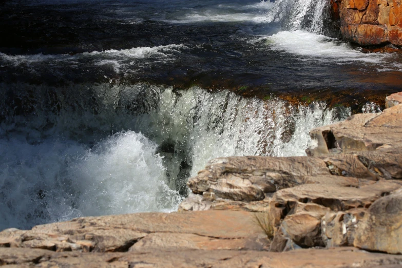 the ocean water is coming out from the rocks