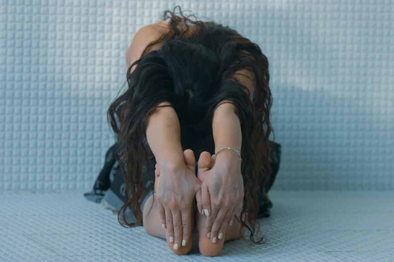 a woman kneeling on the ground with her hands on her head