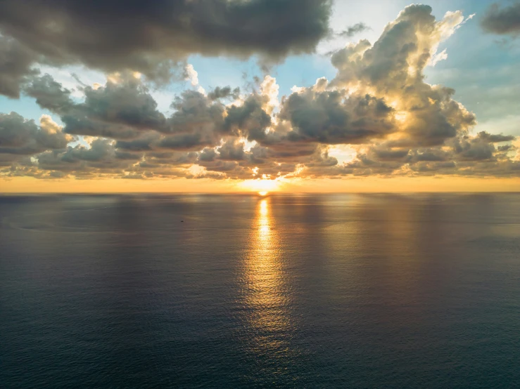 the sun is setting over the ocean as it reflects the water