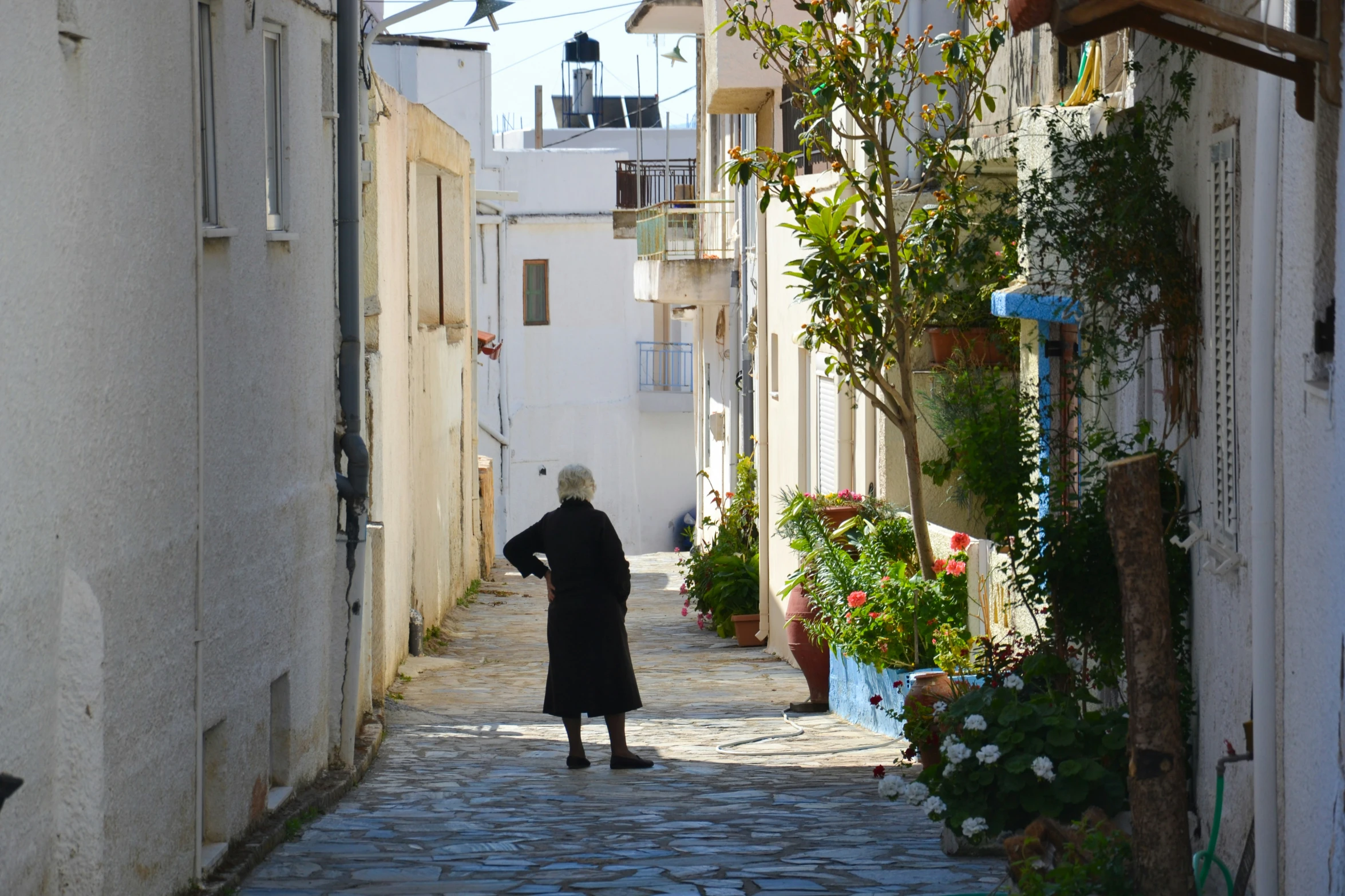 a woman walking down a narrow stone street