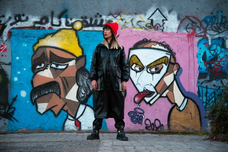 a young woman standing against graffiti painting with a purse