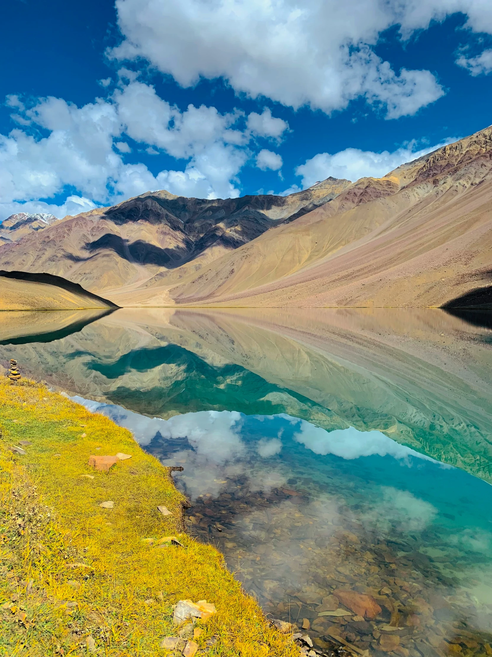 mountains are behind the water on a sunny day