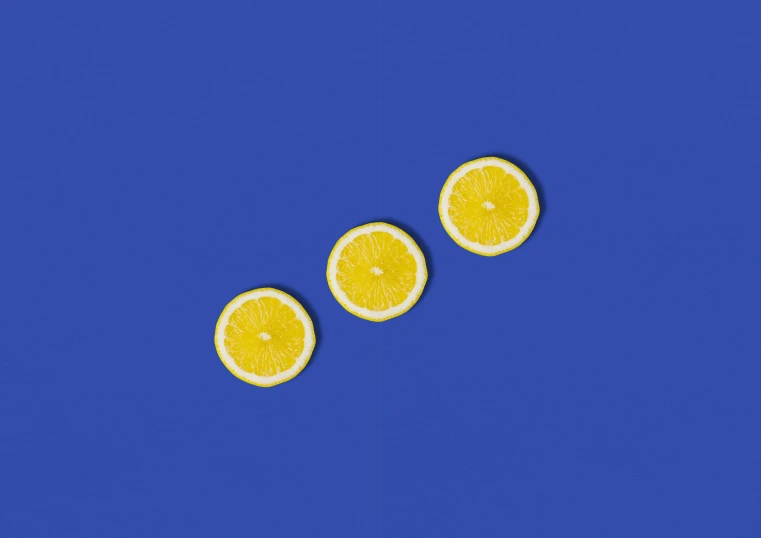 a group of lemons floating on top of a blue surface