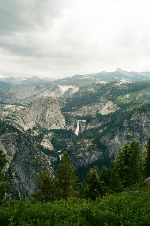 an overlook of mountains with waterfall and forest